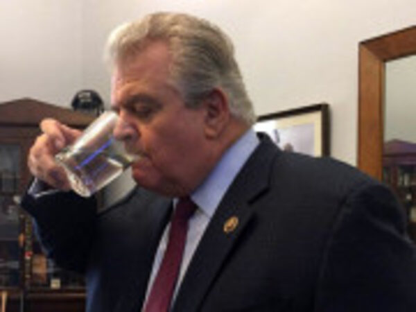 U.S. Rep. Bob Brady sips from a glass of water that had come into contact with the pope.