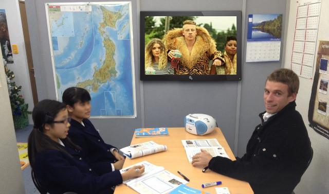 ESL teacher teaching English class using the Macklemore & Ryan Lewis music video ‘Thrift Shop’ and accompanying materials (Image: helloenglish.jp)