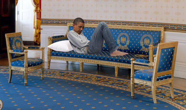 President Barack Obama laying reticent on one of the two Blue Room sofas