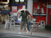 News Crew Waits Patiently For Umbrella To Lose Structural Integrity
